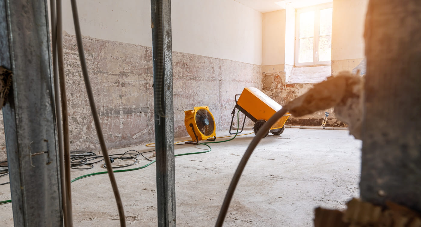 Sous-sol avec ventilateur qui fait sécher l'eau après-sinistre.
